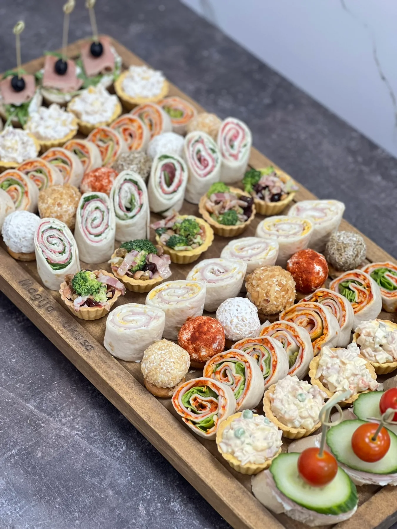 Koktel kanapei i jestive korpice na drvenoj dasci, rolo tortilje, finger food